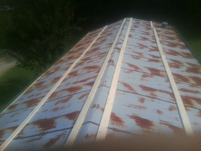 Rusted metal roof panels with new wood purlins before replacement — Storm Damage Roof Repair in Apalachicola by Roofing Brothers