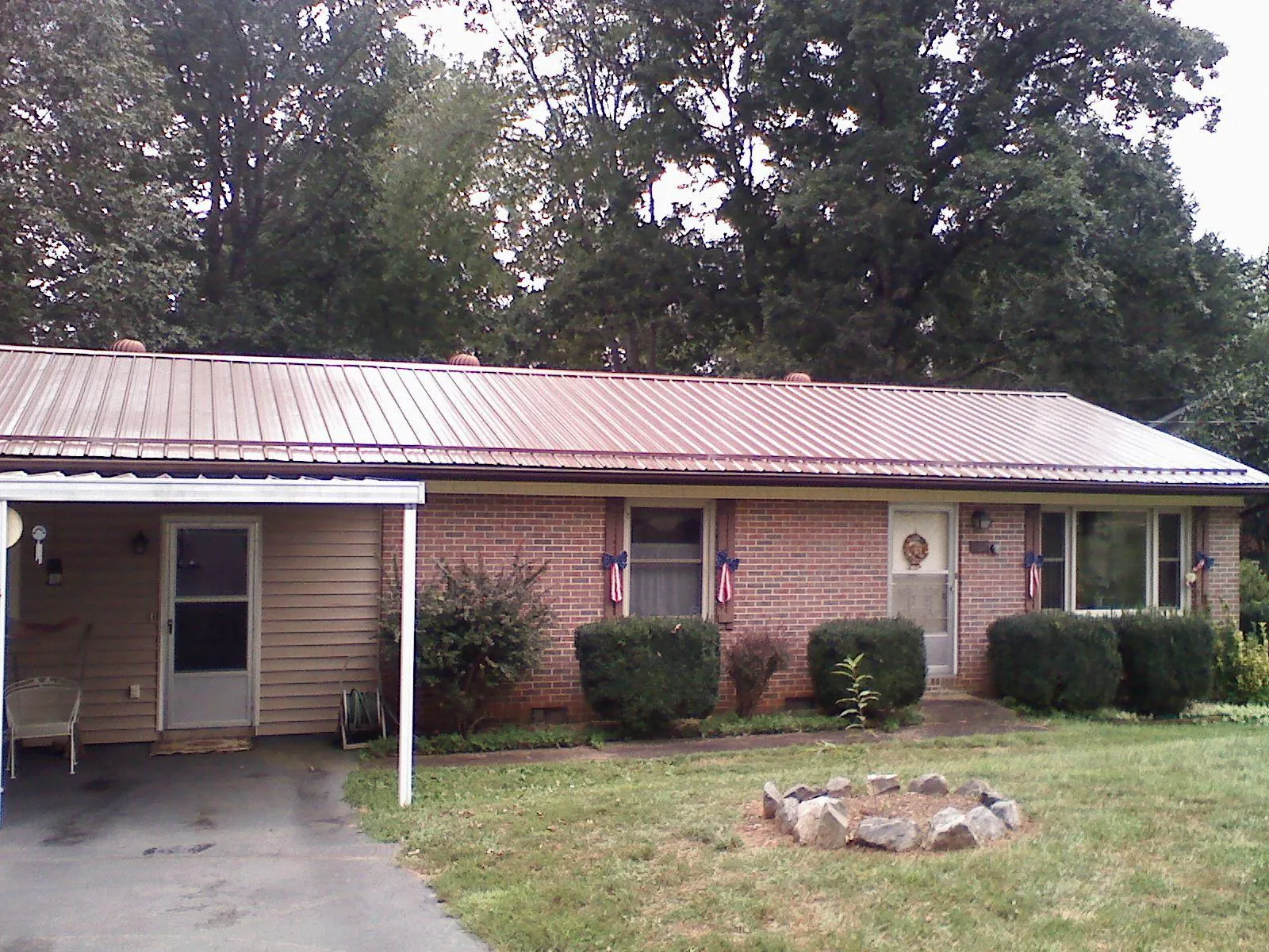 Bronze metal roof and carport on a brick ranch home — Roof Repair work by our crew in Apalachicola