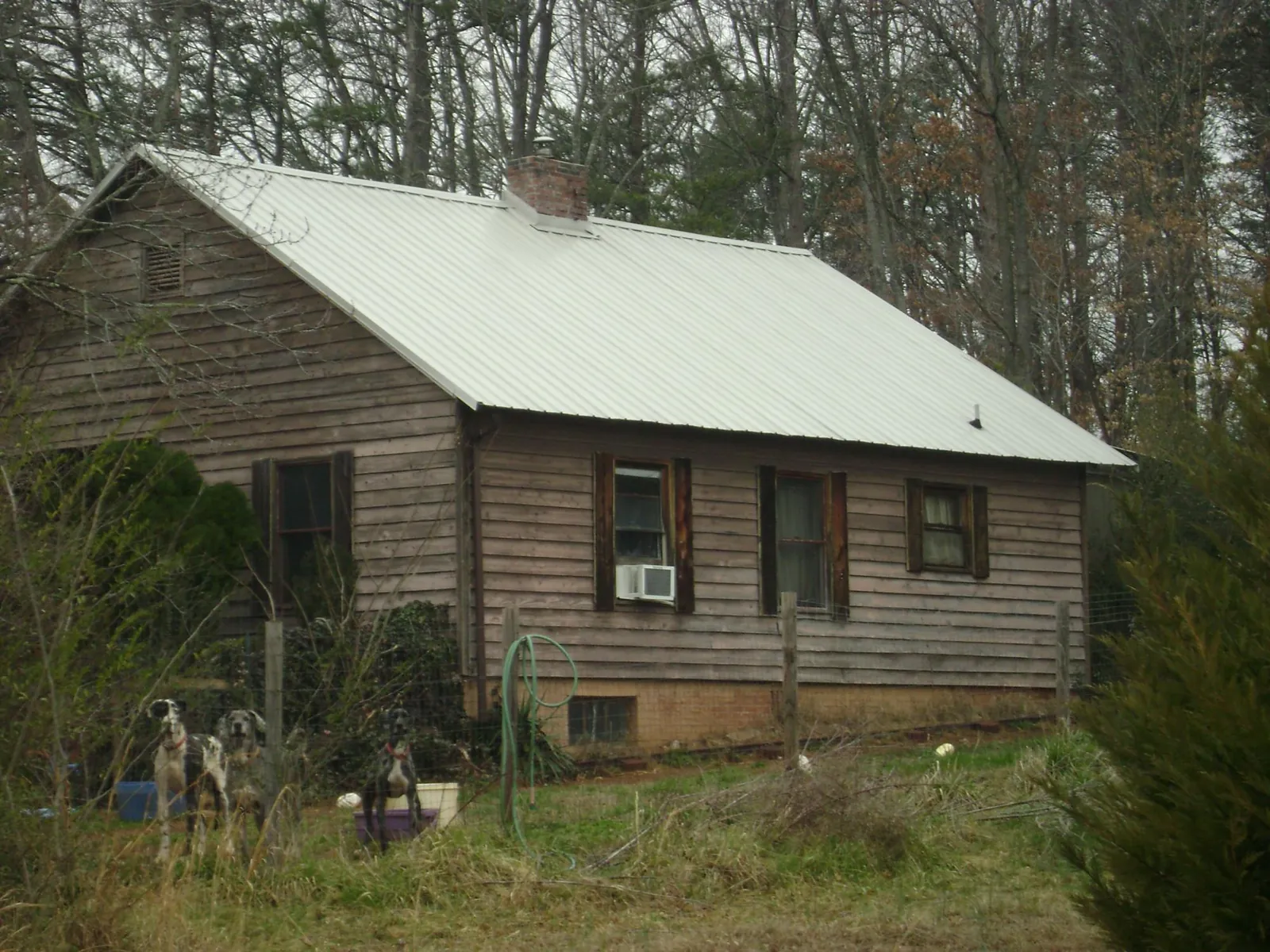 White metal roof on an old wood sided farmhouse, from a Metal Roof Installation job in Apalachicola